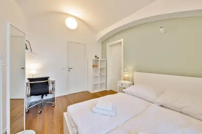 a bedroom with a bed and a desk and a chair at Elegant Apartments close to Center & Bike Path in Prague