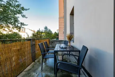 a patio with a table and chairs on a balcony at Elegant Apartments close to Center & Bike Path in Prague