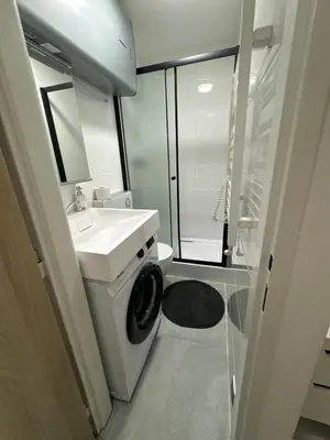 a bathroom with a washing machine and a sink at GeraStay Sokolska in Prague