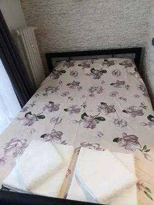 a bed with a bedspread with purple flowers on it at GeraStay Sokolska in Prague