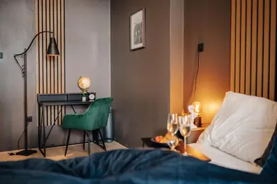 a bedroom with a bed and a table and a chair at Cinema Apartment Billiard & Foosball - City Centre in Prague