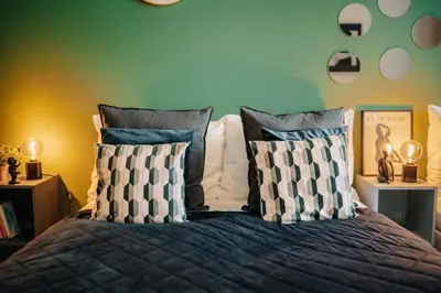 a bedroom with a bed with pillows and a green wall at Cinema Apartment Billiard & Foosball - City Centre in Prague