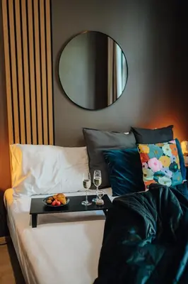 a tray of food and two glasses of wine on a bed at Cinema Apartment Billiard & Foosball - City Centre in Prague