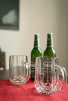 two empty wine glasses sitting on a table with bottles at Artisan & Old-timey 2 bedrooms home in Prague