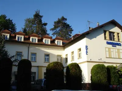 a large white building with bushes in front of it at Hotel Sanssouci in Prague