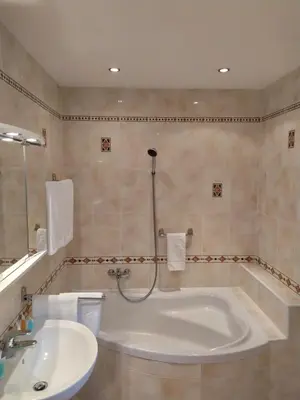 a bathroom with a tub and a sink at Hotel Sanssouci in Prague
