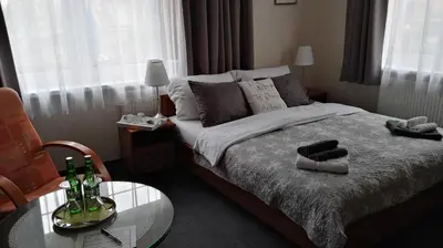 a bedroom with a bed and a glass table with bottles on it at Pension Villa Marit in Prague