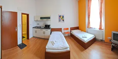 a living room with a couch and a kitchen at Economic Hotel Svoboda in Rakovník