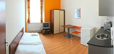 a bedroom with a bed and a desk and a television at Economic Hotel Svoboda in Rakovník