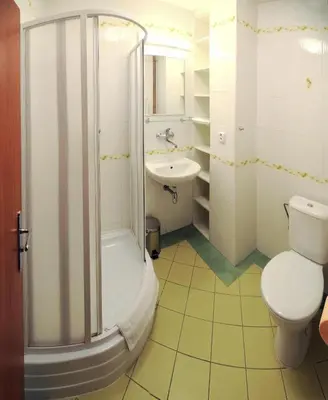 a bathroom with a shower and a toilet and a sink at Economic Hotel Svoboda in Rakovník