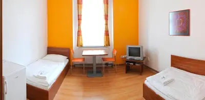 a room with two beds and a tv in it at Economic Hotel Svoboda in Rakovník