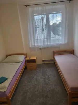 a bedroom with two beds and a window at Komárov Apartment 2 in Komárov
