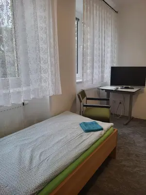 a bedroom with a bed and a desk with a computer at Komárov Apartment 2 in Komárov