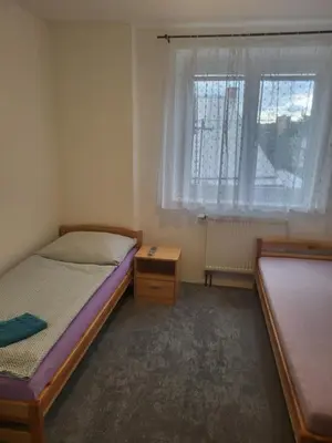 a small bedroom with two beds and a window at Komárov Apartment 2 in Komárov