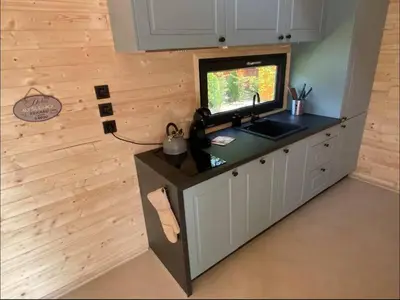 a kitchen with a counter with a sink and a television at Glamping paradise with wellness in Dolní Břežany