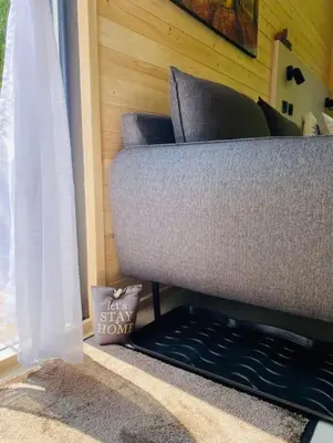 a couch sitting in a living room next to a window at Glamping paradise with wellness in Dolní Břežany