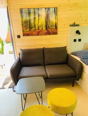 a living room with a couch and two tables and a bed at Glamping paradise with wellness in Dolní Břežany