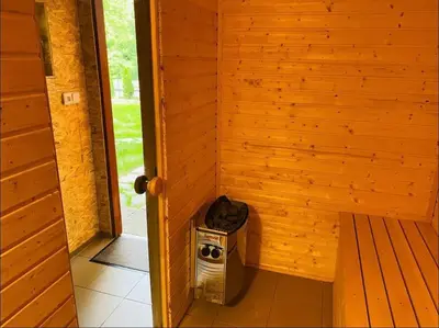 a corner of a wooden wall with a trash can at Glamping paradise with wellness in Dolní Břežany