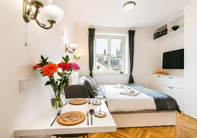 a bedroom with a bed and a table with flowers at Apartment Linda Prague in Prague