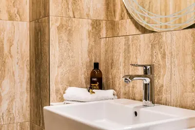 a bathroom with a sink and a bottle of soap at Apartment Linda Prague in Prague