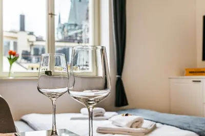 two wine glasses sitting on a table with a window at Apartment Linda Prague in Prague