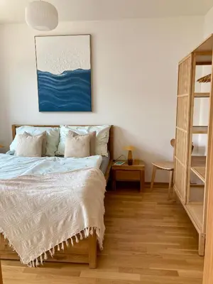 a bedroom with a bed and a painting on the wall at Charming apartment with a balcony in a great location in Prague