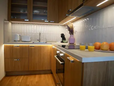 a kitchen with wooden cabinets and oranges on a counter at Charming apartment with a balcony in a great location in Prague