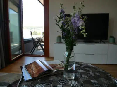 a vase of flowers sitting on a table with a book at Charming apartment with a balcony in a great location in Prague
