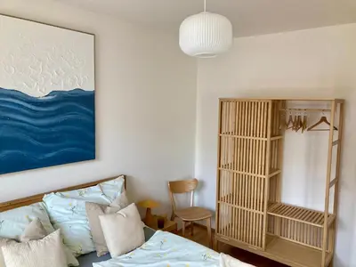 a bedroom with a bed and a painting on the wall at Charming apartment with a balcony in a great location in Prague