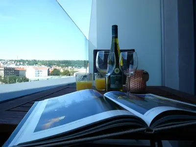 a table with a book and glasses and a bottle of wine at Charming apartment with a balcony in a great location in Prague