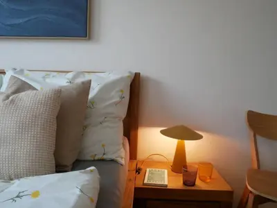 a bedroom with a bed with a table with a lamp at Charming apartment with a balcony in a great location in Prague