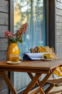 a wooden table with a book and a vase with flowers at Finskä chata in Samopše