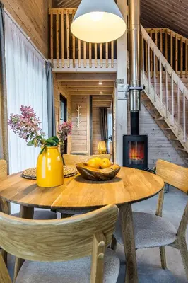 a dining room with a wooden table and a fireplace at Finskä chata in Samopše