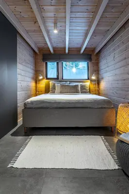 a bedroom with a large bed in a wooden wall at Finskä chata in Samopše