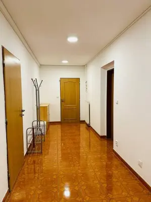 a hallway with white walls and a wooden door and chairs at Family-Friendly Prague 5 Stay in Prague