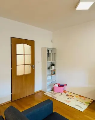a living room with a blue couch and a door at Family-Friendly Prague 5 Stay in Prague