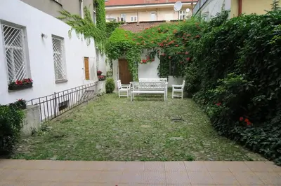 a patio with a bench in a yard next to a building at Apartments near Lesser Town in Prague