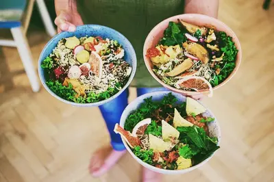 a person holding three bowls of food in their hands at Apartments near Lesser Town in Prague