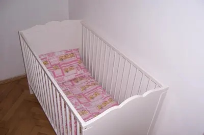 a white crib with a blanket on it at Apartments near Lesser Town in Prague