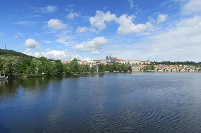 a large body of water with a bridge in the background at Apartments near Lesser Town in Prague