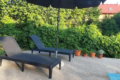 two chairs and an umbrella on a patio at Klasický dům, 5 ložnic , 5 bedrooms, Praha in Prague