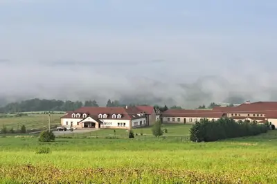 a large building in the middle of a field at Лесной Коттедж Нова in Živohošť