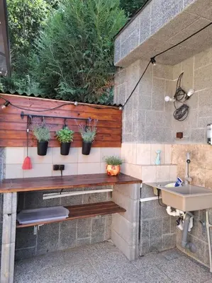 a bathroom with a sink and potted plants on the wall at Лесной Коттедж Нова in Živohošť
