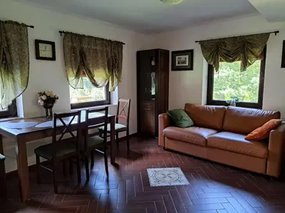 a living room with a couch and a table at Лесной Коттедж Нова in Živohošť