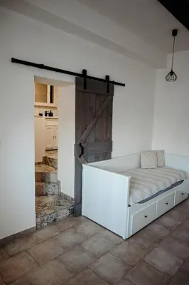 a bedroom with a bed with a barn door at Vítovský statek in Žižice