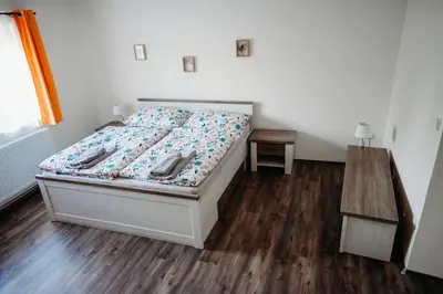 a bedroom with a bed with a wooden floor at Vítovský statek in Žižice