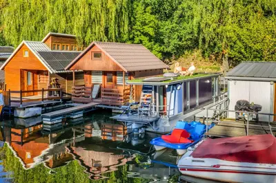 a house on a dock on the water with a boat at Houseboat Prague with Paddle Boat -Sail, Explore and Relax in Prague