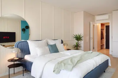 a bedroom with a large bed with white and blue at Good Vibe Studio near Metro - Garage, Air-Conditioning, Vinyl player in Prague