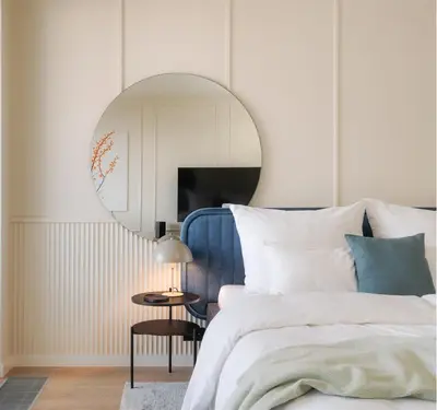 a bedroom with a blue bed and a round mirror at Good Vibe Studio near Metro - Garage, Air-Conditioning, Vinyl player in Prague
