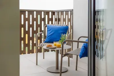 a chair and a table with a blue pillow at Good Vibe Studio near Metro - Garage, Air-Conditioning, Vinyl player in Prague